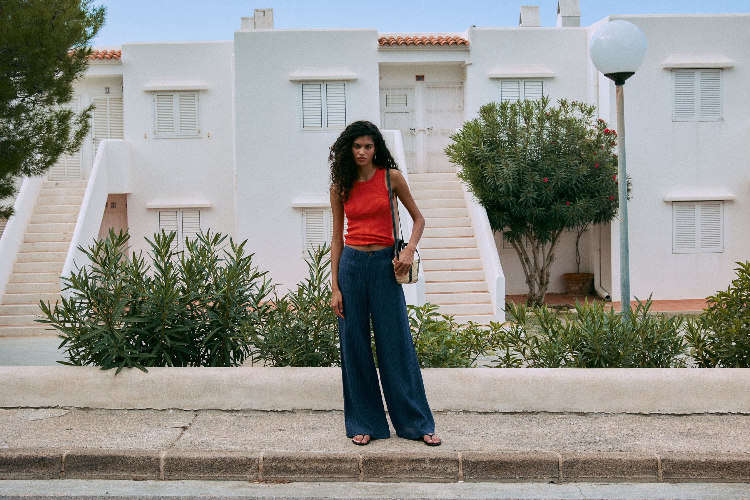 Fashion shoot on location in Ibiza — model at a whitewashed building